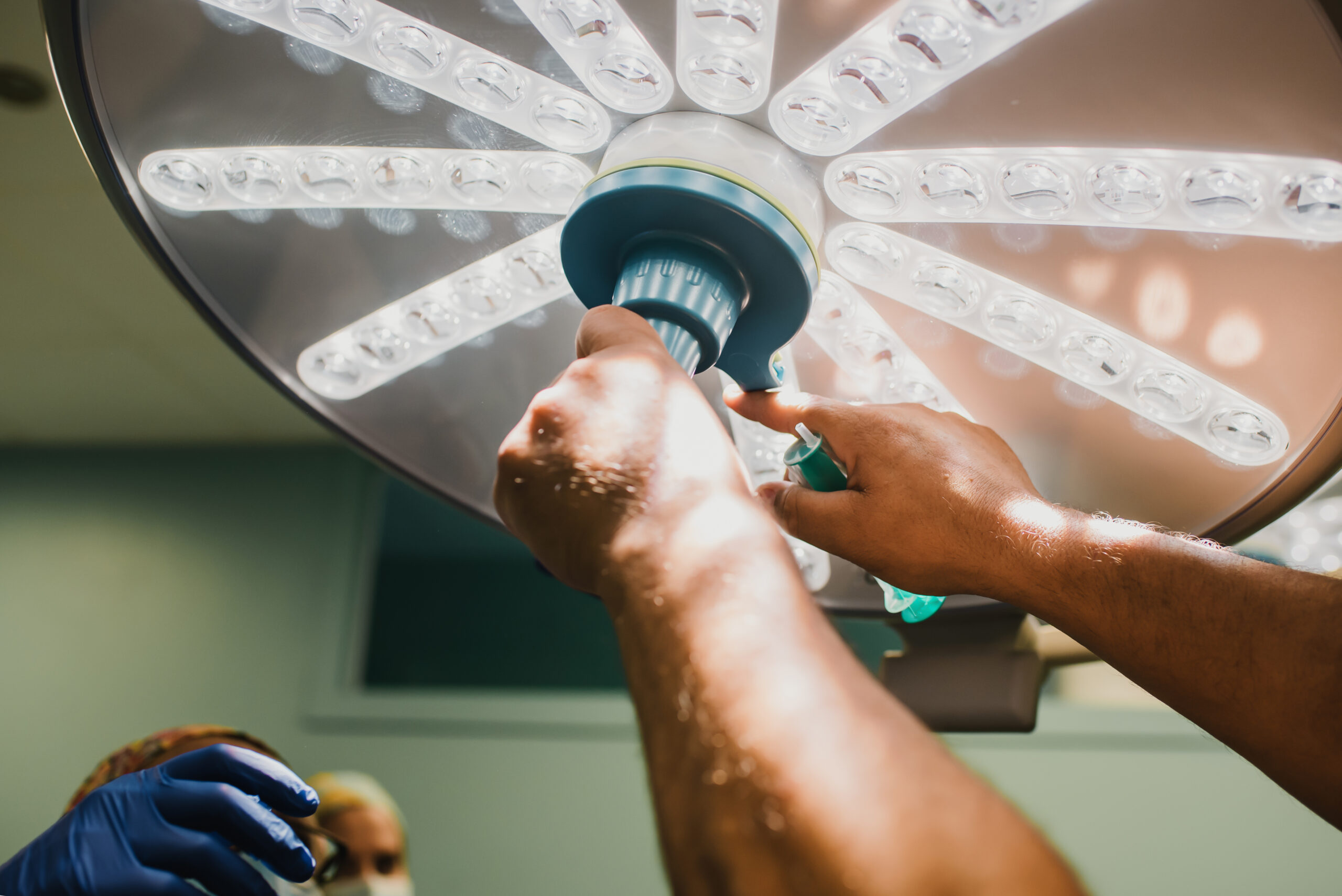 Medical people preparing surgical equipment for operation inside private clinic - Focus on lamp